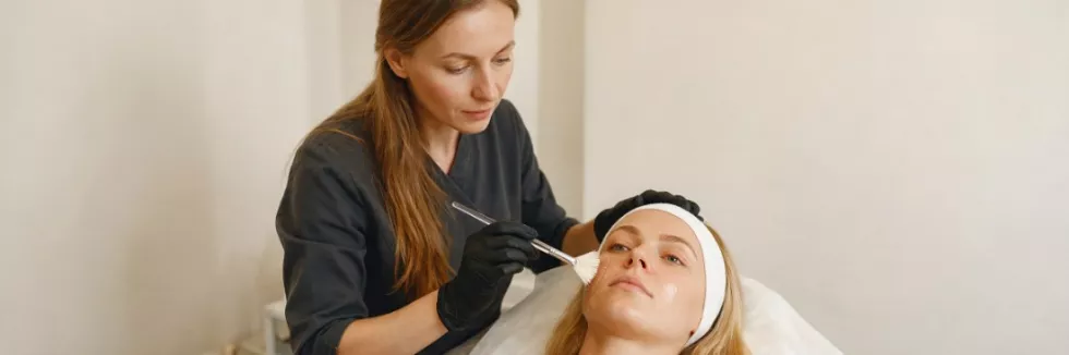 kosmetolożka wykonuje peeling chemiczny klientce