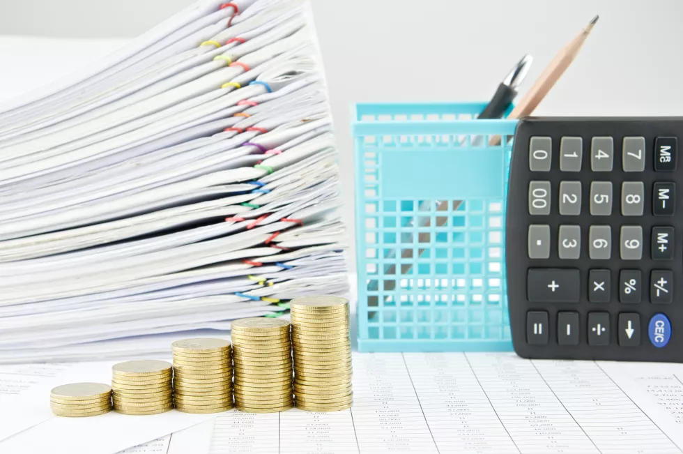 high-angle-view-coins-stacked-by-calculator-table