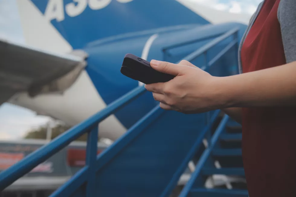 blonde-female-tourist-checking-incoming-notification-smartphone-sitting-seat-airplane-with-netbookyoung-businesswoman-share-media-from-telephone-laptop-computer-plane-flight