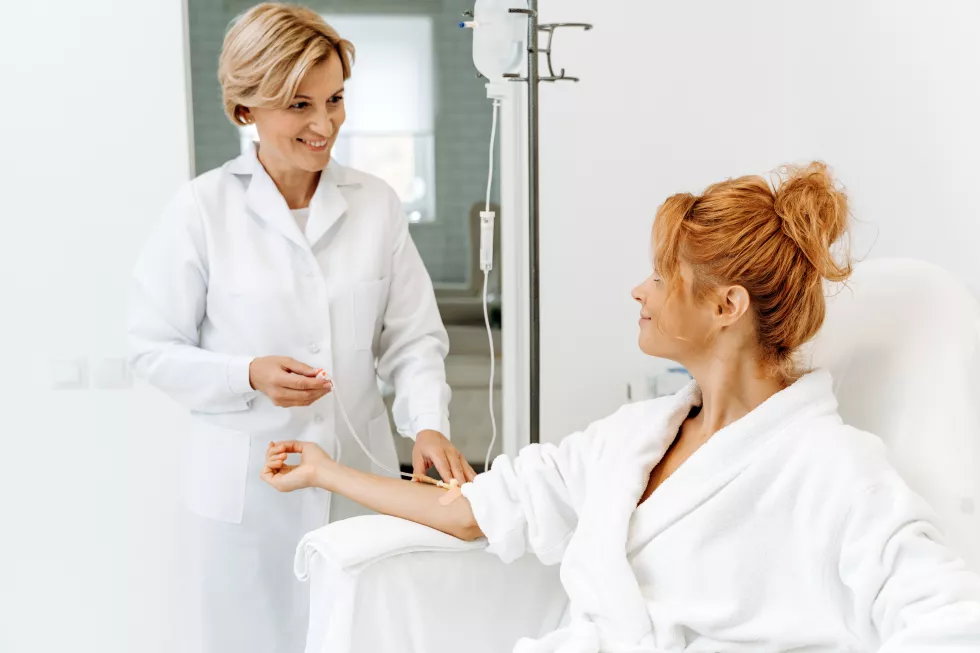 side-view-portrait-attractive-woman-white-bathrobe-sitting-armchair-with-pleasure-smile-while-receiving-iv-infusion