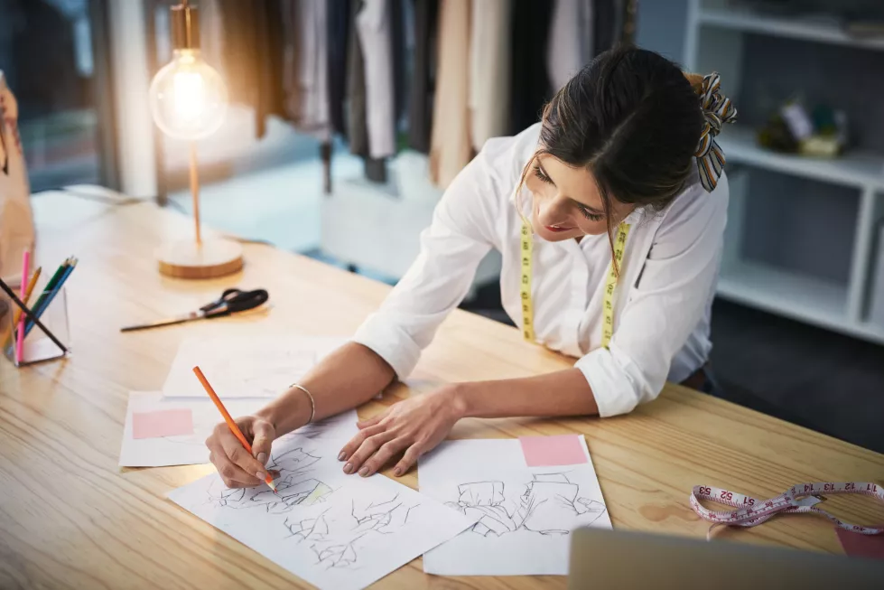 happy-fashion-designer-working-drawing-sketches-planning-luxury-clothes-workshop-tailor-designing-writing-with-smile-vision-ideas-creative-project-startup-night