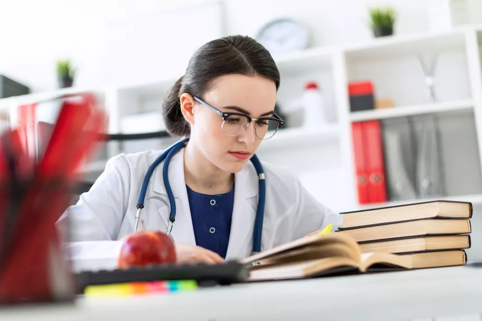 beautiful-young-girl-white-robe-is-sitting-computer-desk-with-marker-book