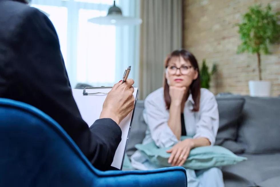 female-psychologist-having-therapy-with-middleaged-woman-patient-office