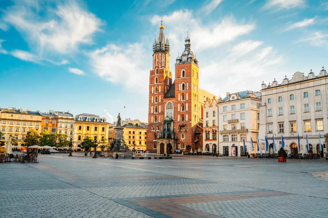 Main Market Square in Kraków with St Mary’s Basilica on a sunny day.