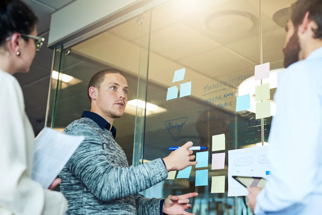 heres-grand-plan-shot-group-businesspeople-brainstorming-with-notes-glass-wall-office