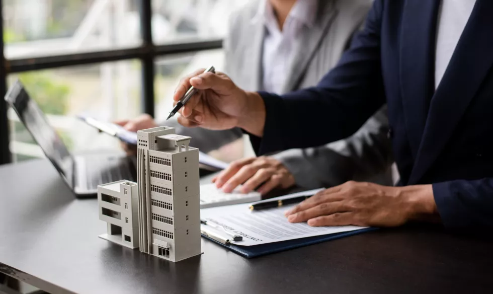 salesman-hands-house-model-small-toy-house-small-mortgage-property-insurance-concepts-real-estat