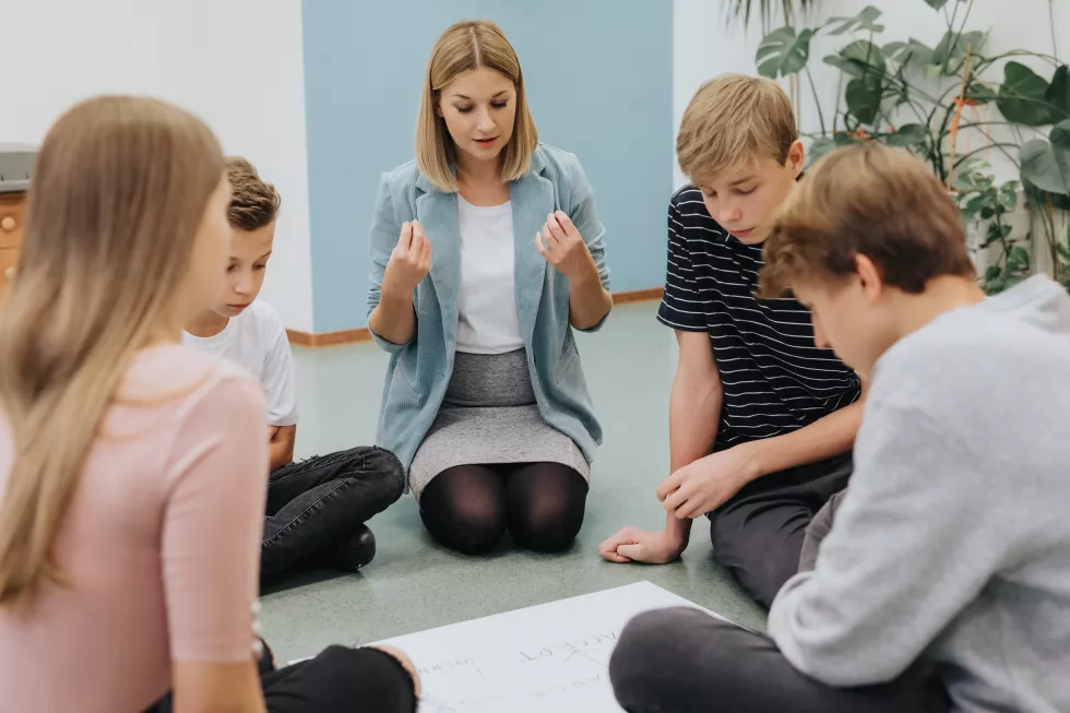 young-teacher-helps-group-students-prepare-project-workshop