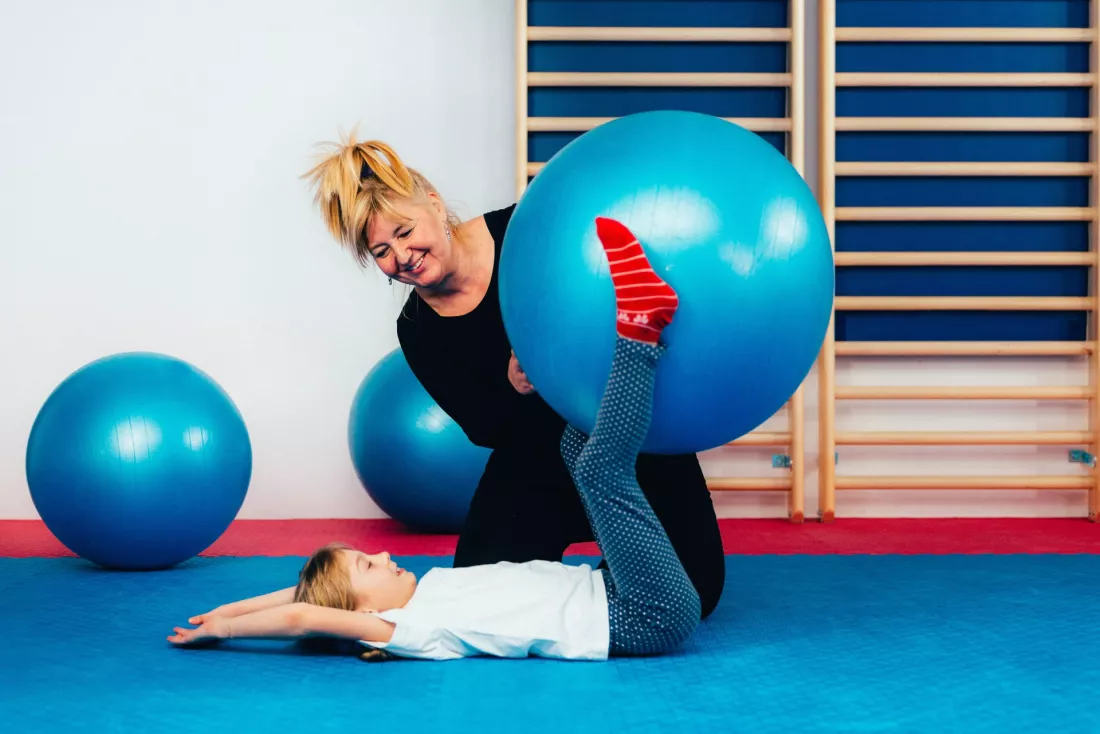 terapia-dziecka-z-pilka-w-sali-rehabilitacji