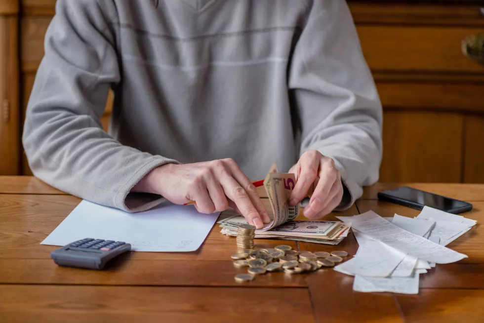midsection-man-holding-paper-while-sitting-table