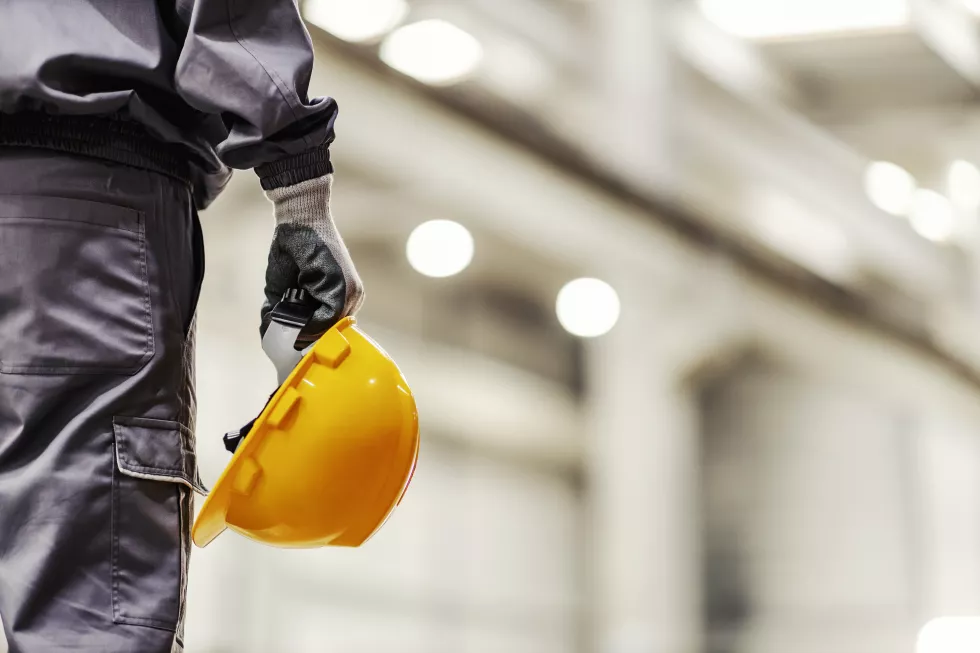 close-up-worker-holding-helmet-heavy-industry-factory
