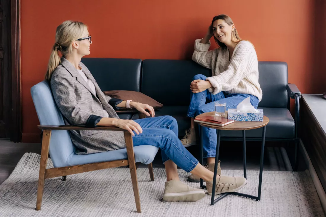 relaxed-young-woman-talking-with-therapist-cozy-office-pleasant-conversation-two-women