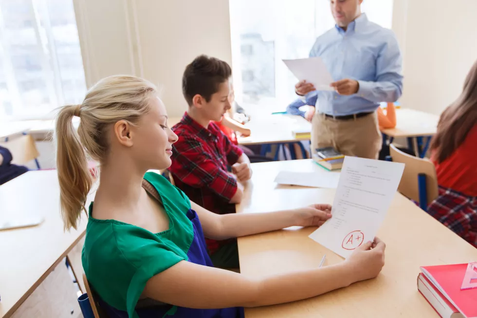 education-school-learning-people-concept-group-students-teacher-with-test-results-classroom