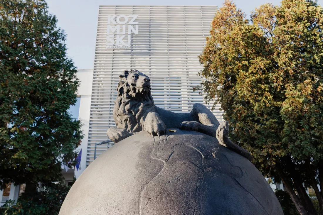 Rzeźba lwa na kuli ziemskiej przed budynkiem Akademii Leona Koźmińskiego w Warszawie