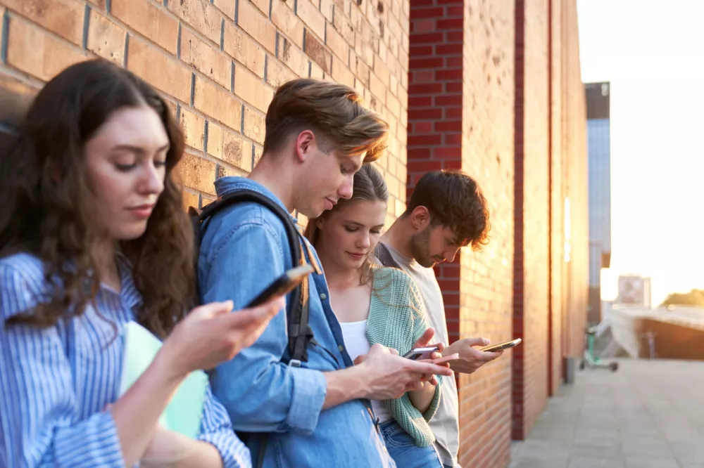 Studenci przegladaja informacje w smartfonach