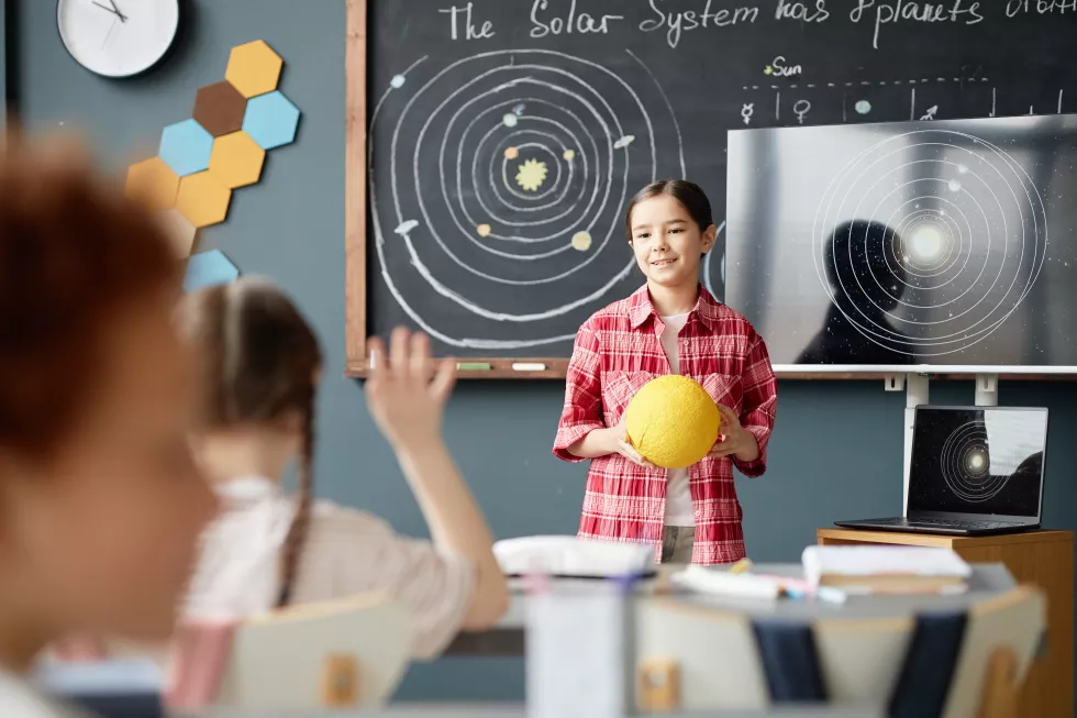 preteen-caucasian-girl-explaining-solar-system-model-science-lesson