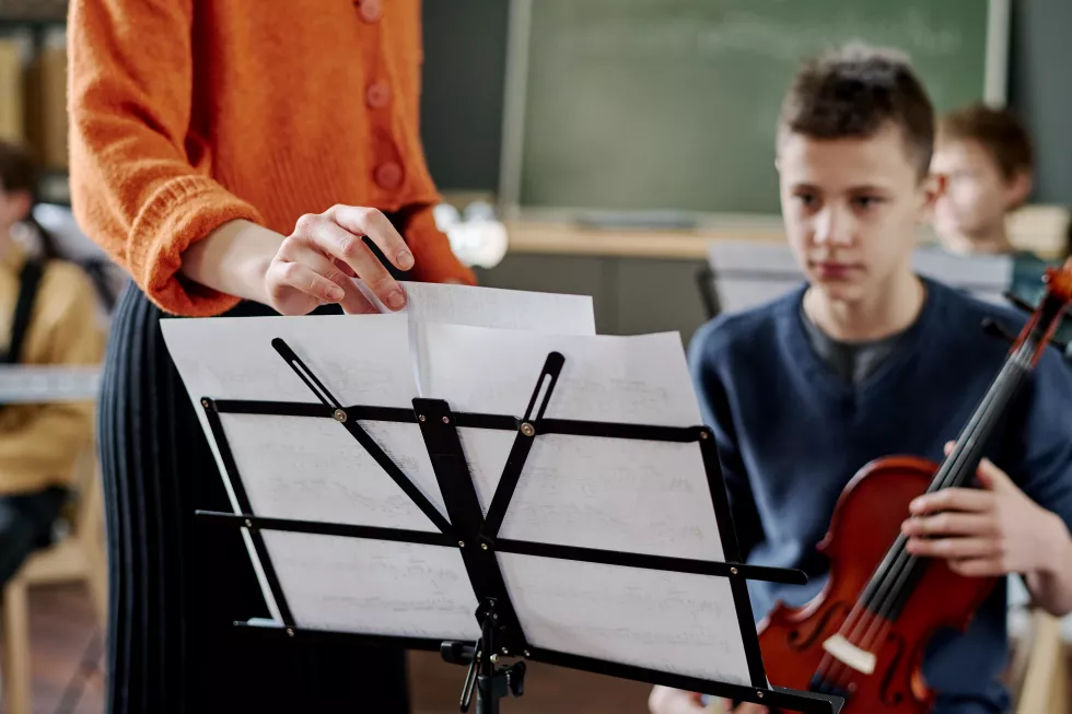 unrecognizable-teacher-working-with-school-orchestra