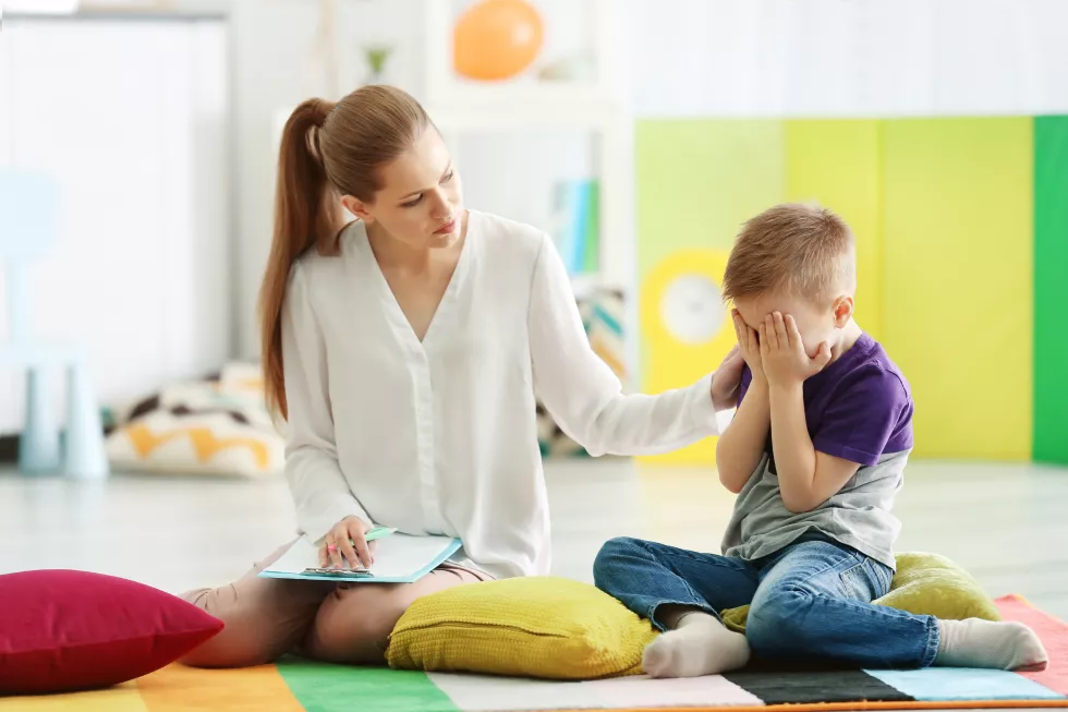 young-female-psychologist-working-with-little-boy-office