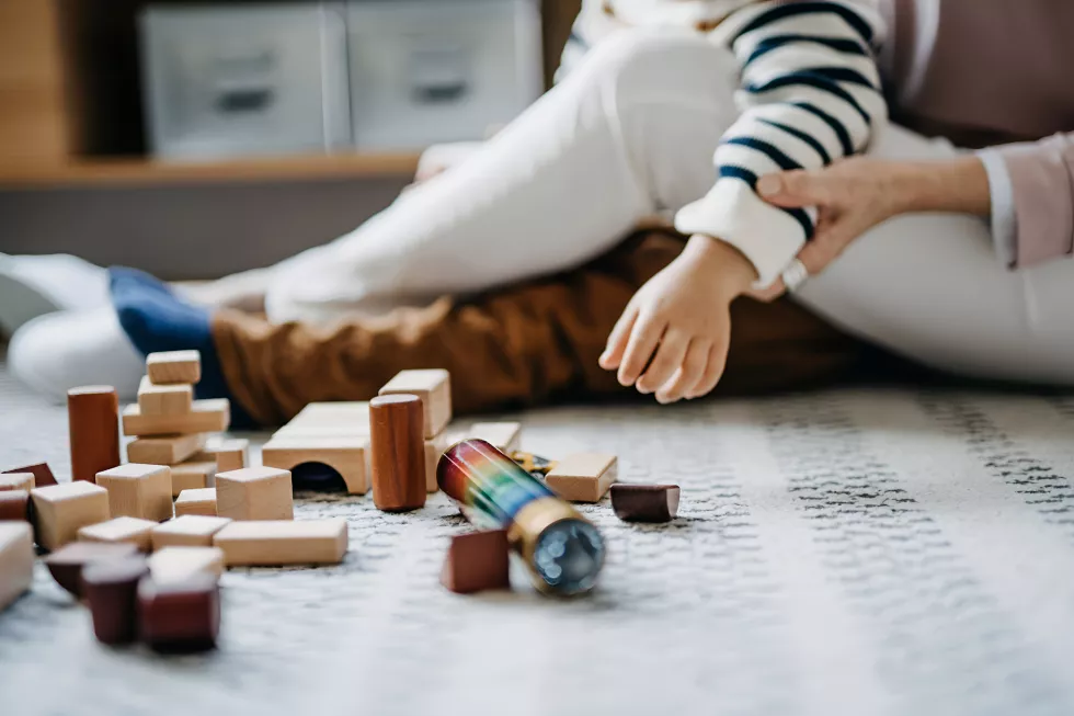 close-up-joyful-asian-grandmother-sitting-floor-living-room-playing-wooden-building-blocks-with-little-grandson-together