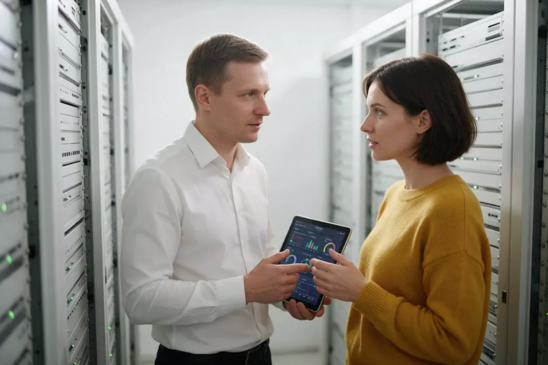 specjaliści rozmawiają w serwerowni z tabletem