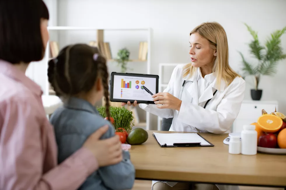 mature-caucasian-female-doctor-shows-tablet-graphs-food-healthy-eating