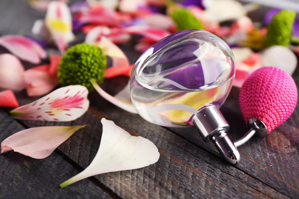 bottle-perfume-flowers-petals-wooden-background