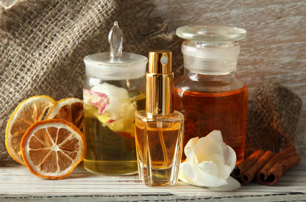 bottles-with-ingredients-perfume-wooden-background