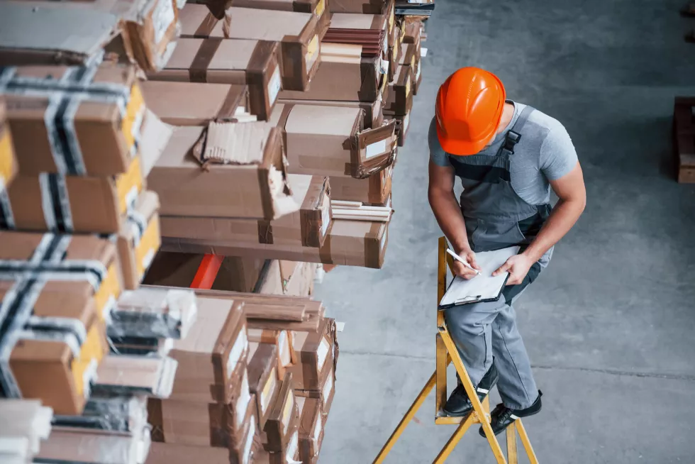 top-view-male-worker-warehouse-with-notepad-hands