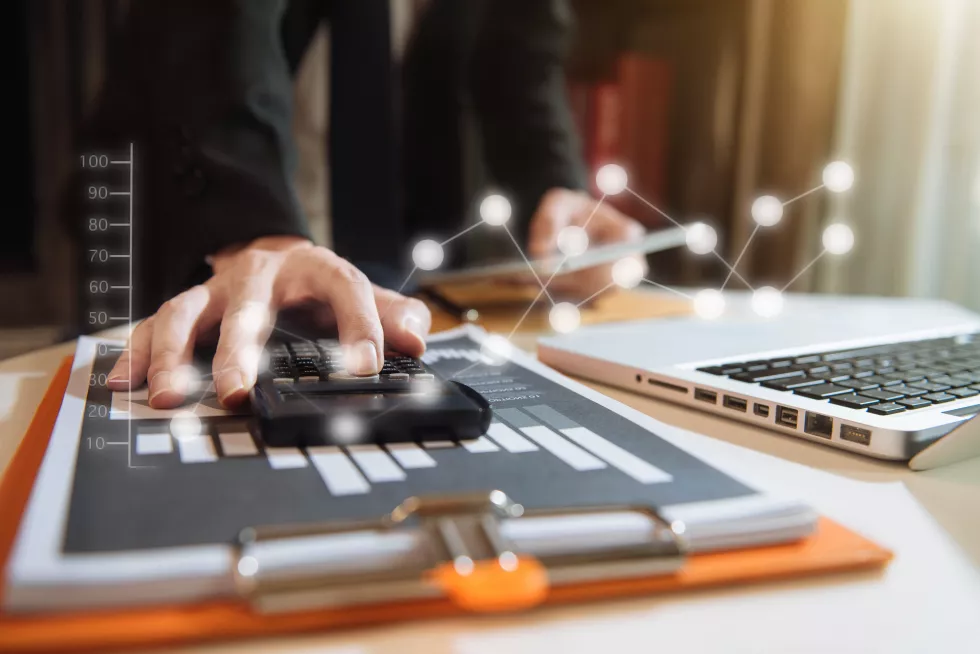 digital-composite-image-businessman-using-calculator-with-illuminated-connecting-dots-office