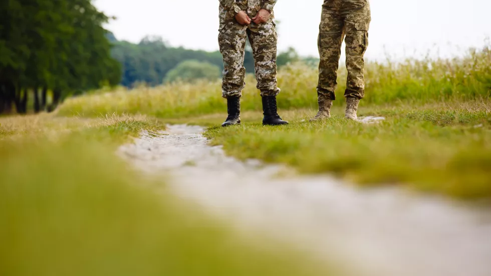 view-legs-two-men-military-uniforms-boots-near-pathway-field