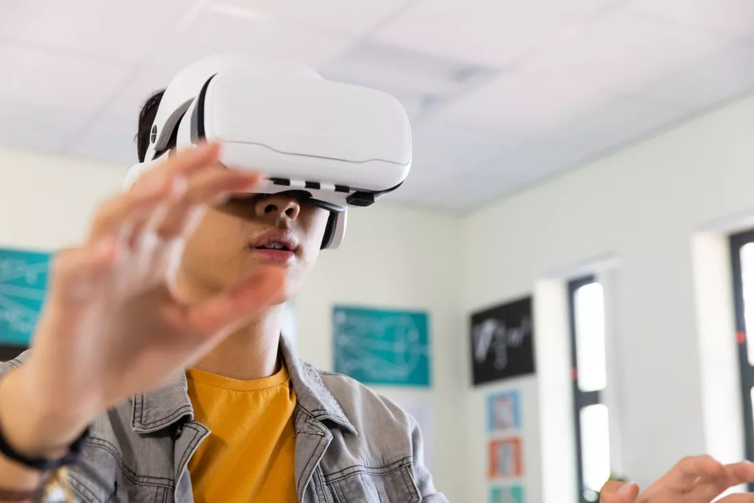 A student explores a virtual world through a VR headset during class