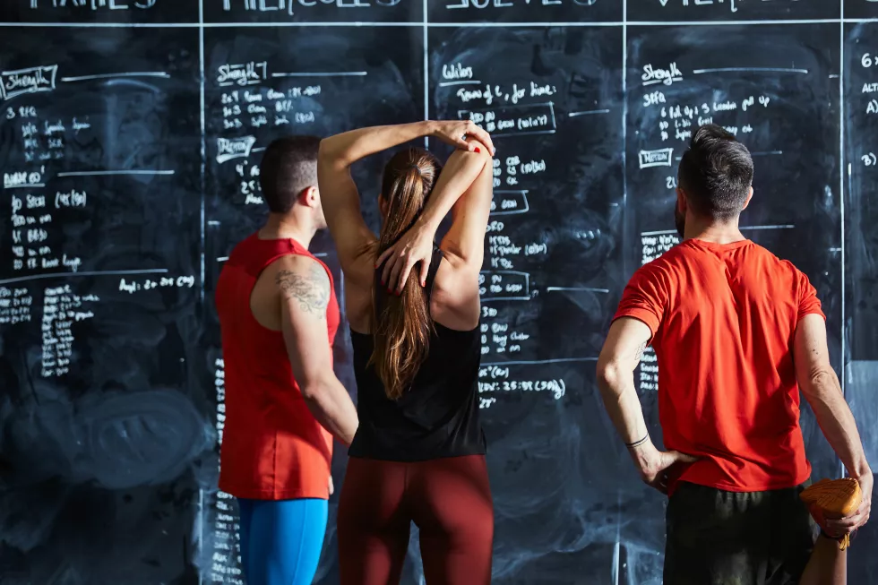 rear-view-woman-man-looking-blackboard
