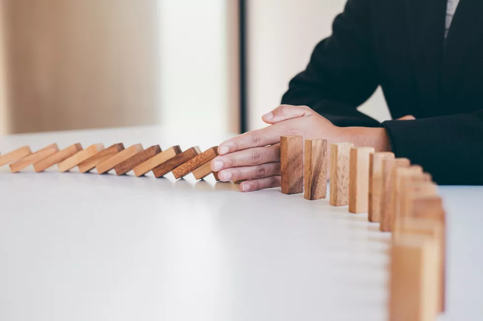 midsection-man-stopping-toy-blocks-table