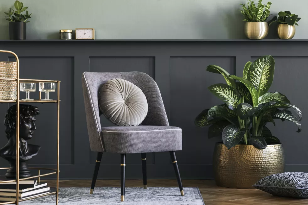stylish-modern-composition-living-room-with-design-gray-armchair-gold-liquor-cabinet-plants-elegant-personal-accessories-gray-wall-panelling-with-shelf-modern-home-decor