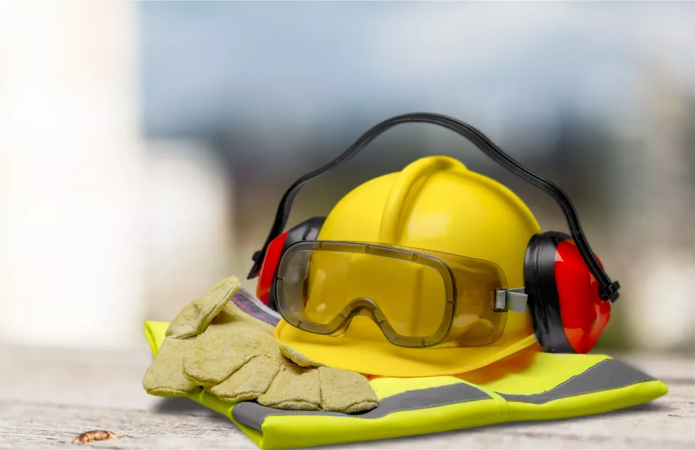 safety-helmet-with-earphones-goggles-construction-background