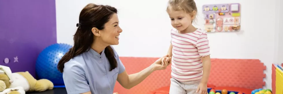 integracja-sensoryczna-diagnoza-i-terapia-terapeutka-prowadzi-dziewczynke-po-rownowazni-w-sali