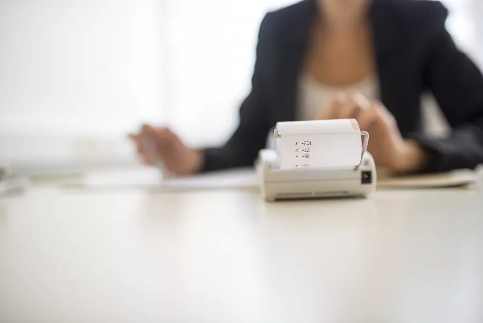 midsection-woman-using-mobile-phone-while-sitting-table