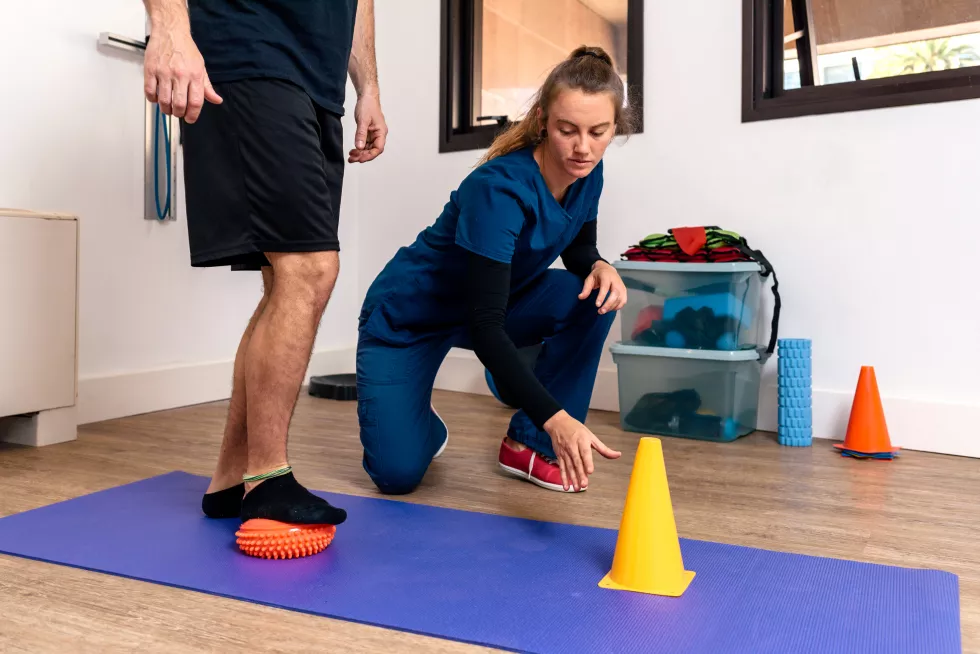 stock-photo-man-receiving-help-by-physiotherapist-professional-woman