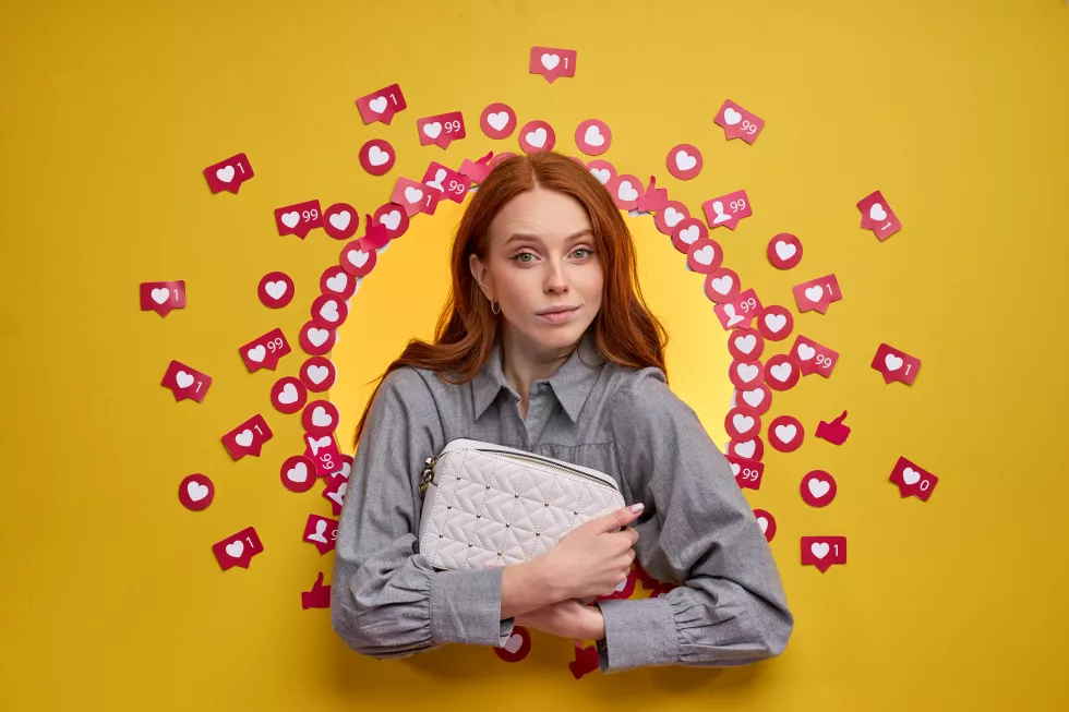 redhead-female-reviews-new-bag-showing-subscriber-audience-holding-purse-hands