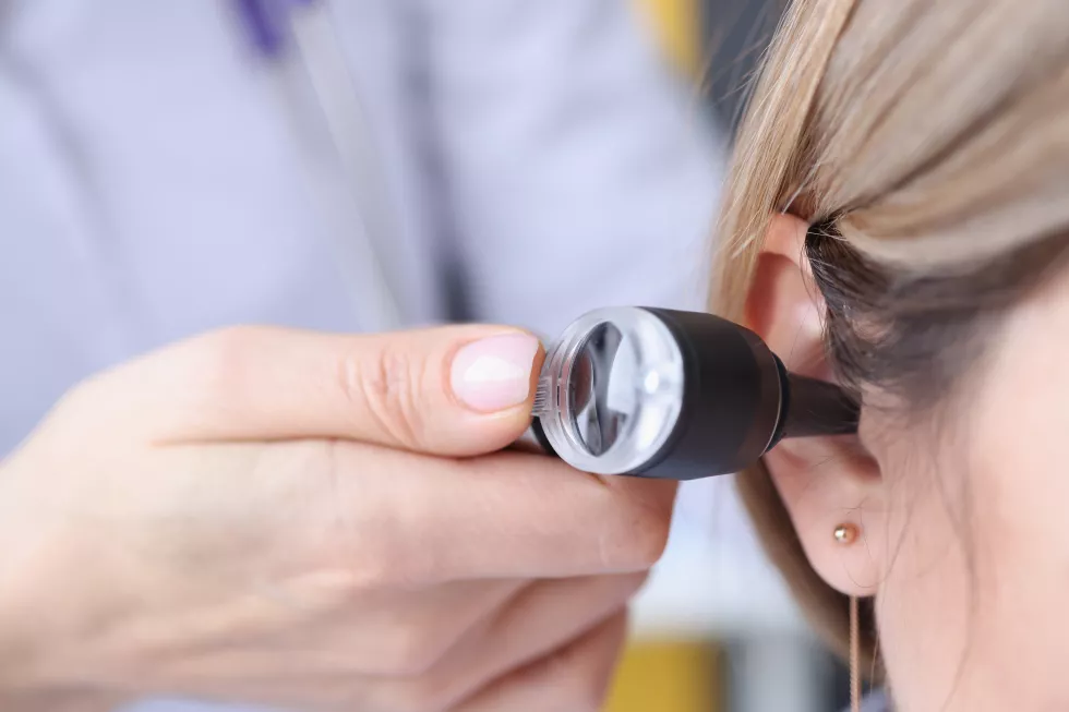 otorhinolaryngologist-looking-patients-ear-using-otoscope-closeup