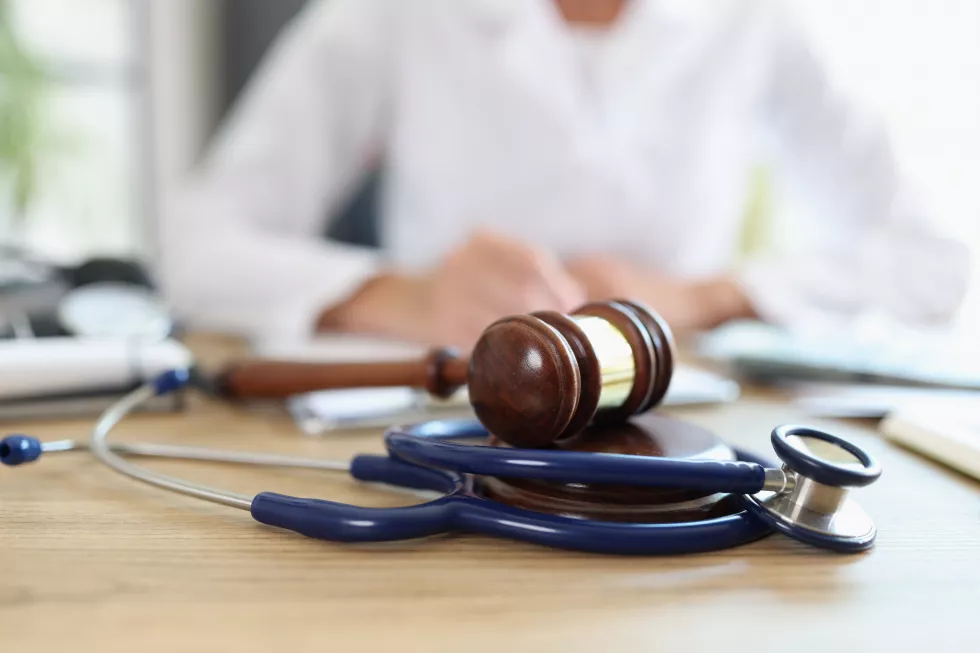 closeup-judge-gavel-stethoscope-doctor-background-writing-notes-concept-legal
