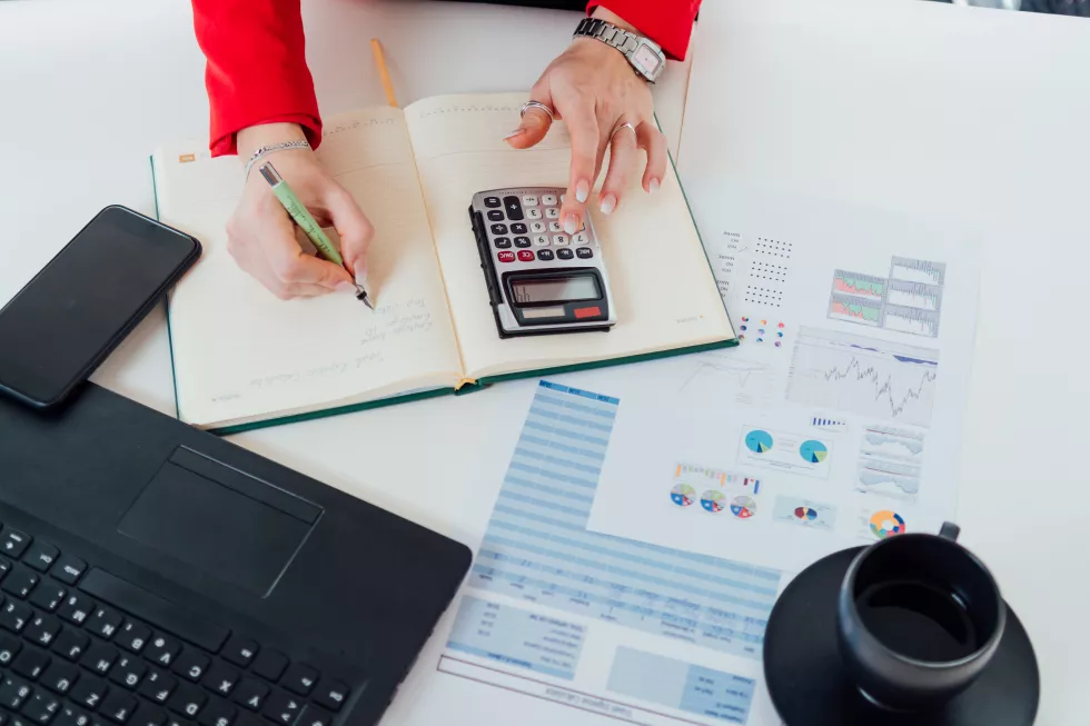 cropped-hand-businesswoman-writing-book-office