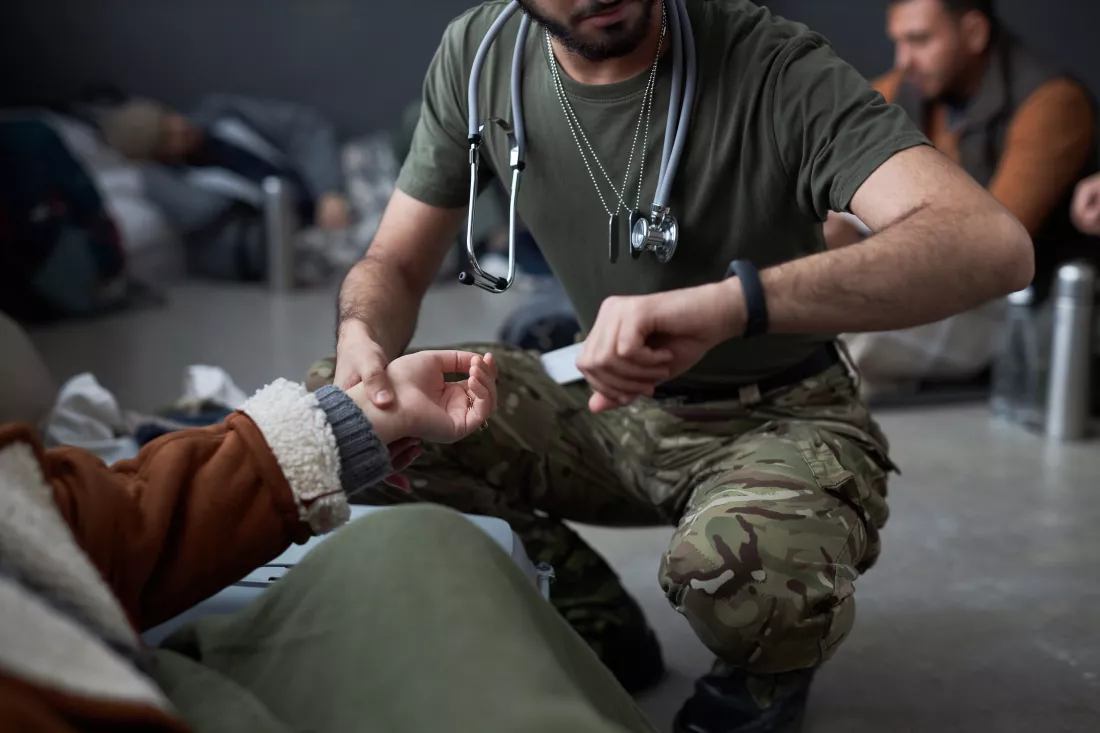 doctor-examining-female-refugee-shelter