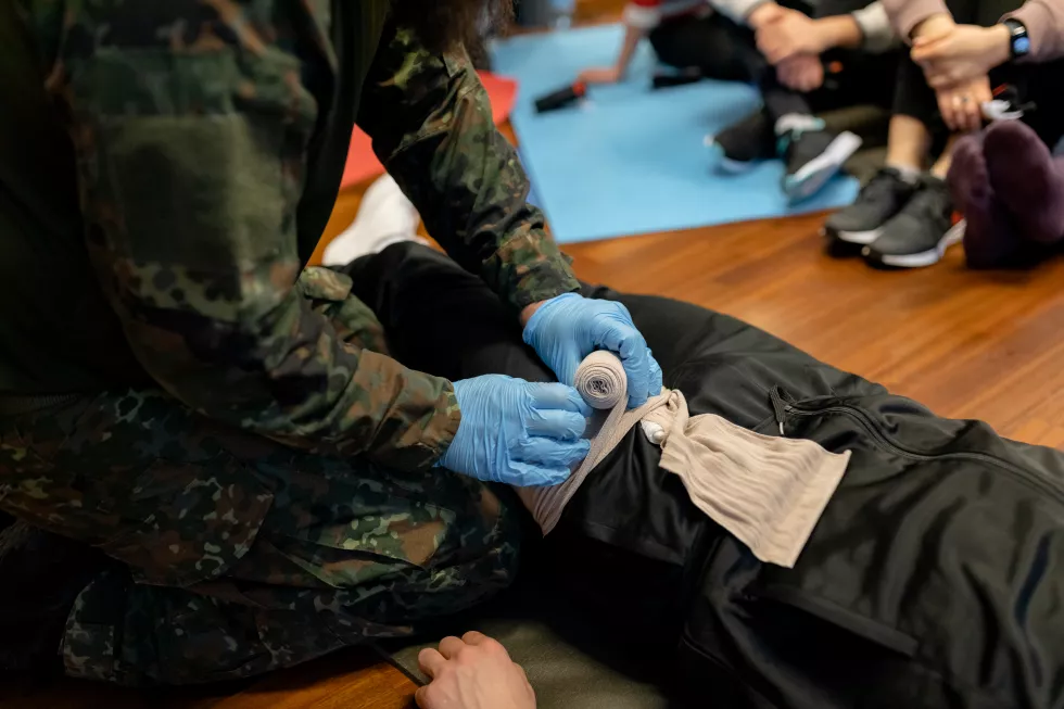 bearded-military-medic-demonstrates-how-tampon-wound-closeup