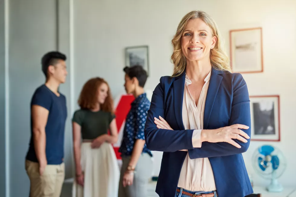 portrait-smile-business-woman-with-arms-crossed-office-integrity-pride-career-growth-face-leader-confident-employee-manager-creative-director-coworking-with-team-startup
