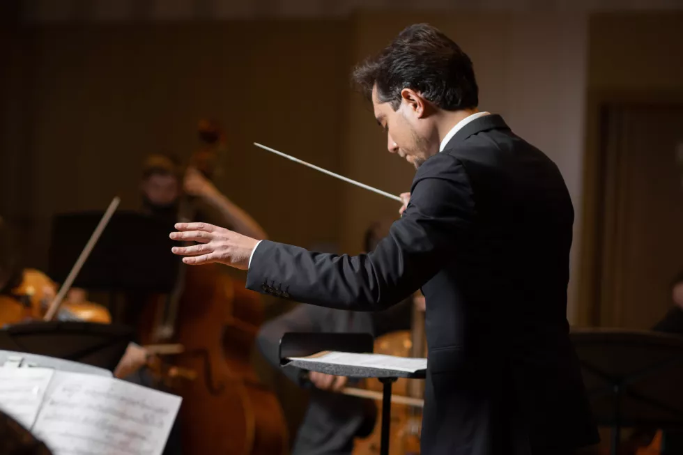 conductor-symphony-orchestra-with-performers-concert-hall-background