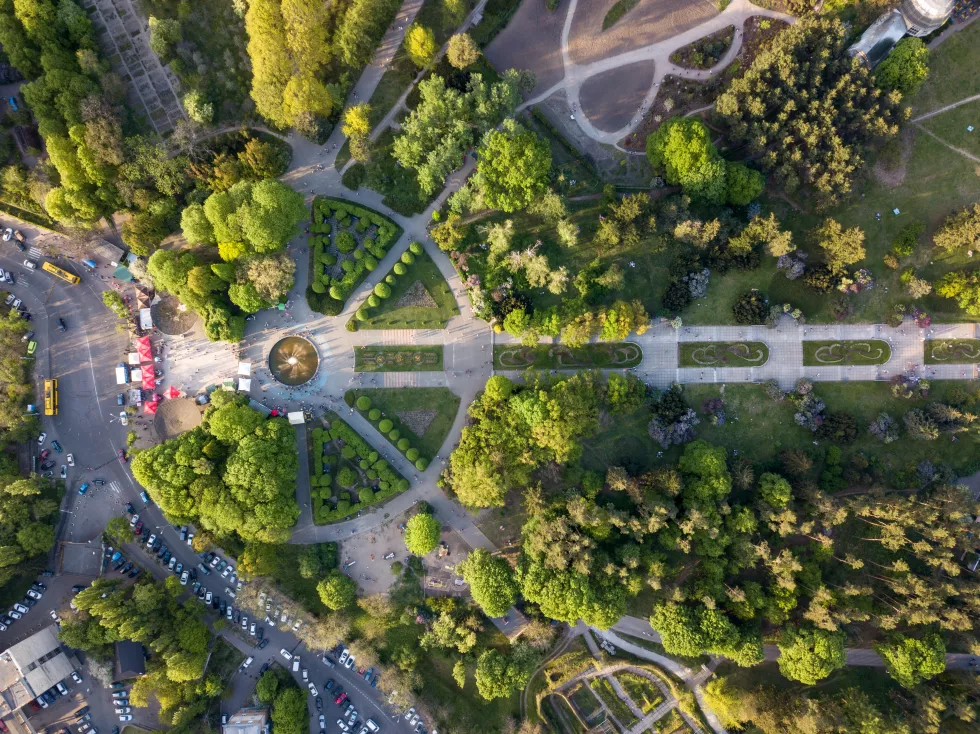 aerial-view-city-kiev-is-botanical-garden-with-alleys-people-walk-road-with-parked-cars
