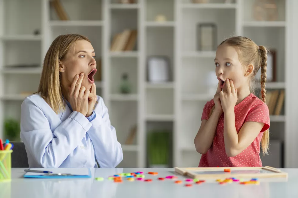 speech-therapist-woman-making-articulation-exercises-with-little-girl-therapy-session