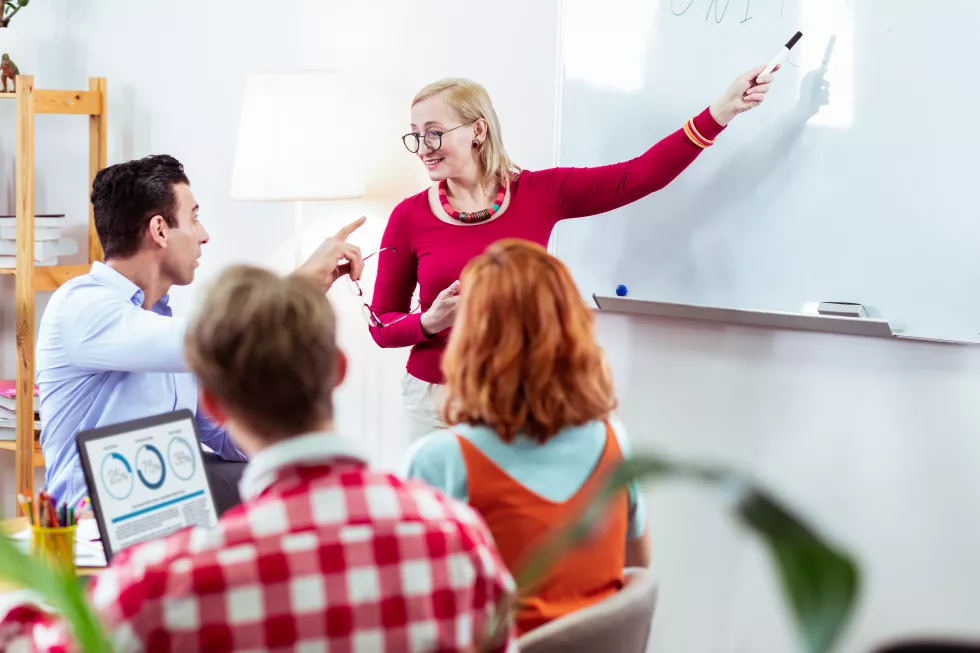 whiteboard-positive-delighted-woman-smiling-while-pointing-inscription-whiteboard