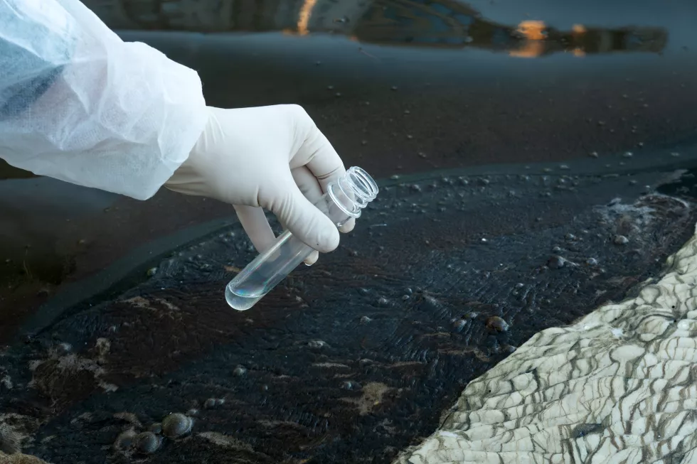 scientists-with-protective-suit-holding-test-tube-with-sample-water-their-hands-water-pollution-examine-concept-test-tube-with-water-background-dirty-muddy-water
