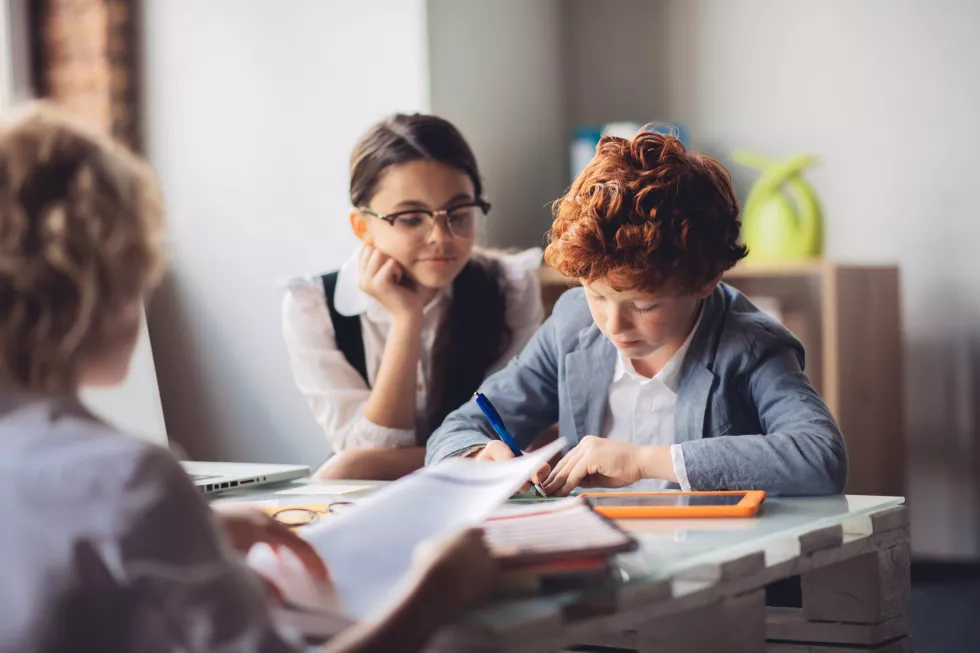 learning-process-red-haired-boy-studying-with-his-friends-looking-concentrated